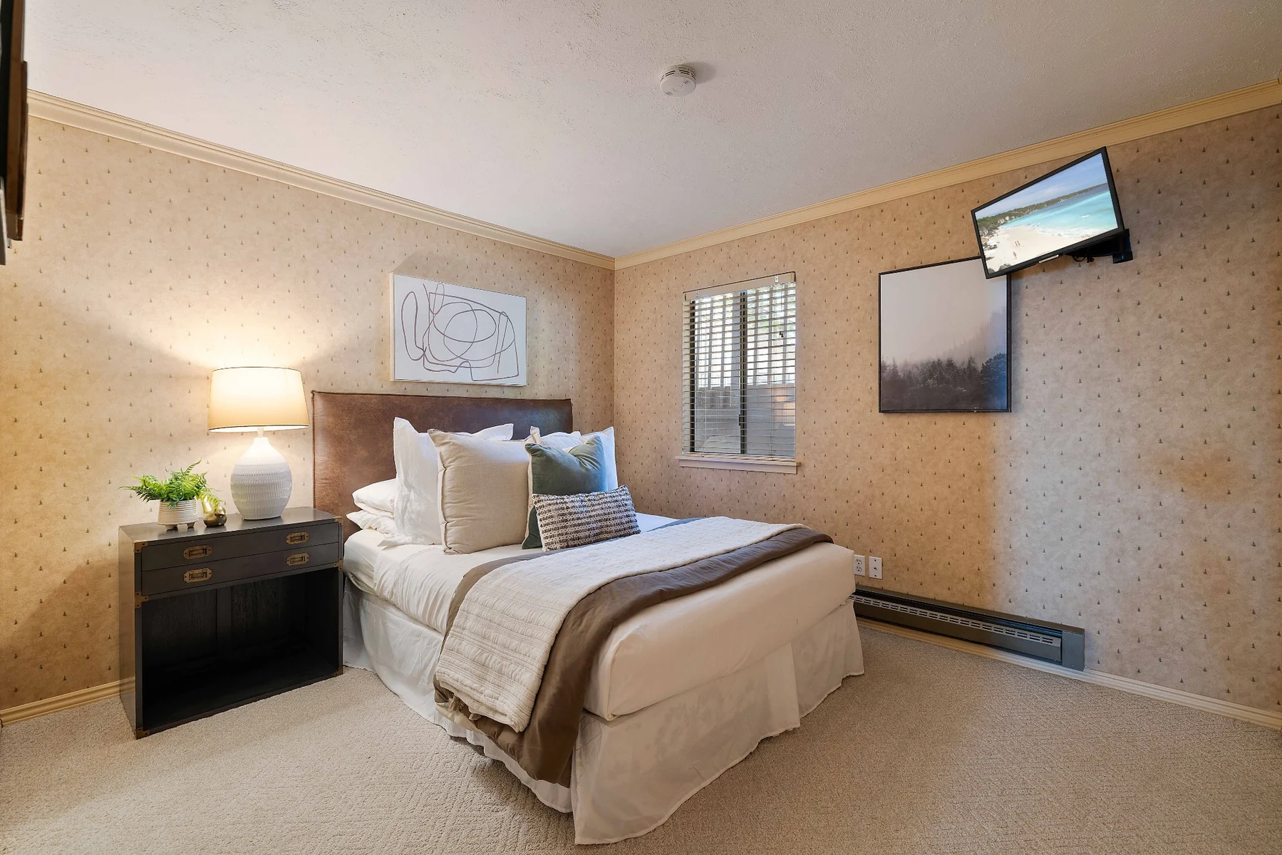 Guest bedroom with queen bed and mounted television
