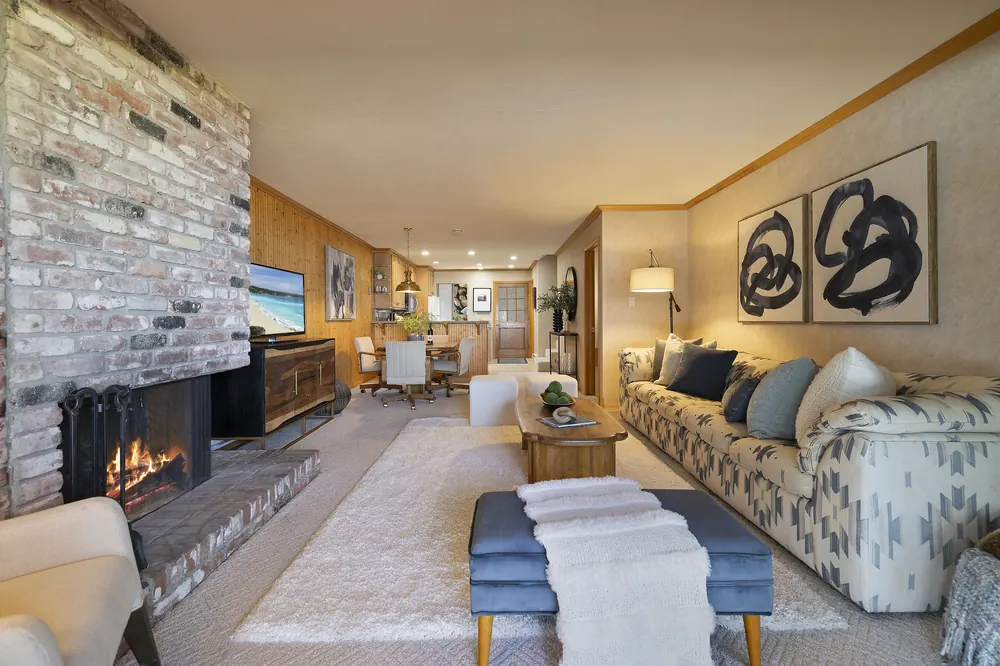Open-concept living and dining area with fireplace and lake-view kitchen